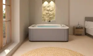 Nowoczesne jacuzzi w łazience z kamienną ścianą i widokiem na balkon.