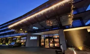Wejście do hotelu Radisson Resort Kołobrzeg nocą, ozdobione lampkami.