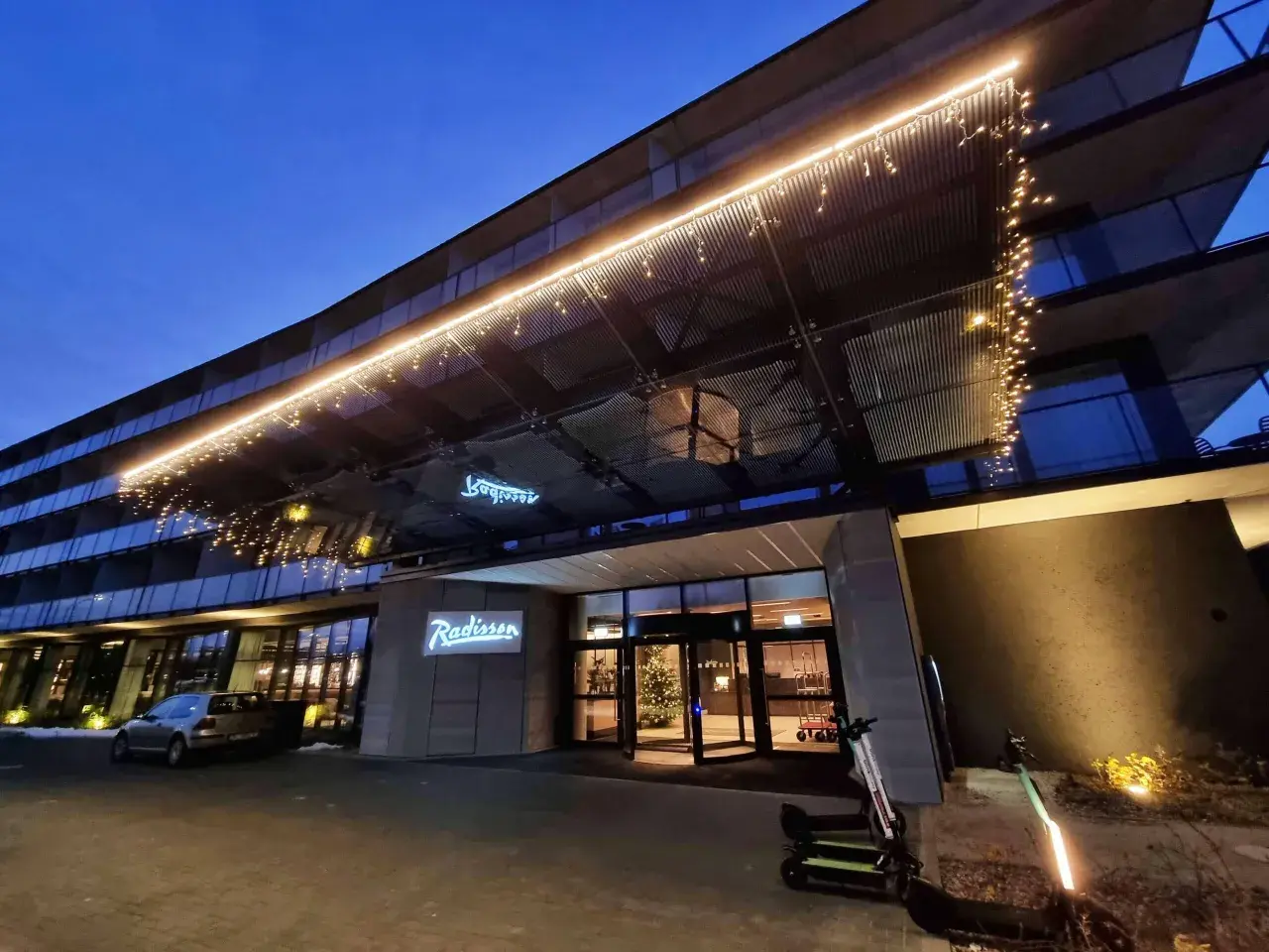 Wejście do hotelu Radisson Resort Kołobrzeg nocą, ozdobione lampkami.