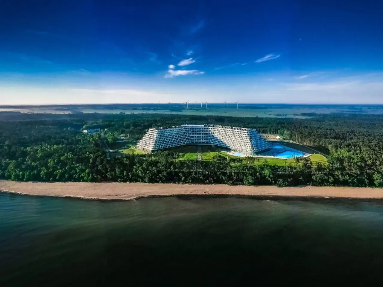 Nowoczesny hotel Gołębiewski w Pobierowie z basenem, otoczony lasem, nad morzem.