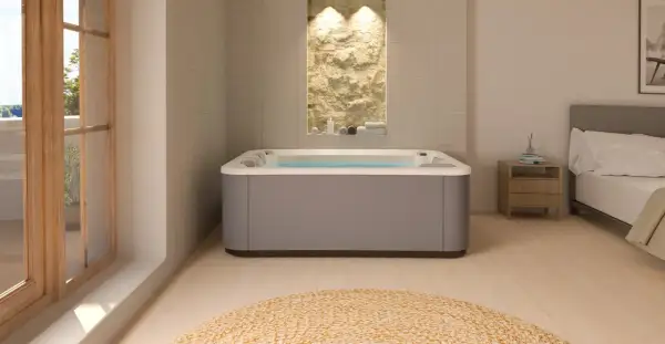 Nowoczesne jacuzzi w łazience z kamienną ścianą i widokiem na balkon.