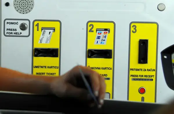 Automat do płatności za autostrady z miejscami na włożenie biletu, karty i odbiór paragonu.